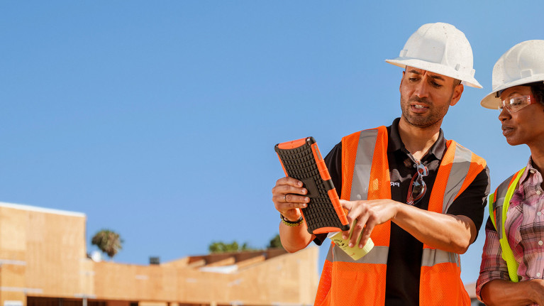 Contractors working with a tablet on the field